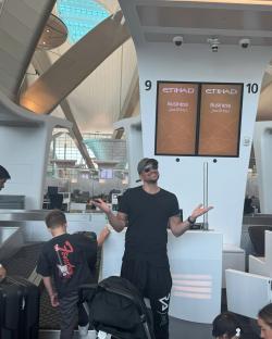 Man at airport check-in with family.