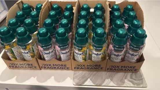 Multiple bottles of Comfort Scent Booster Elixir on store shelves.