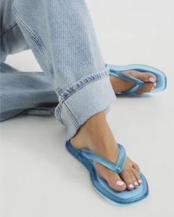 Person wearing light blue jelly sandals.