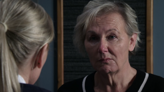 Screenshot of a woman with short gray hair speaking to a person with blonde hair in a ponytail.