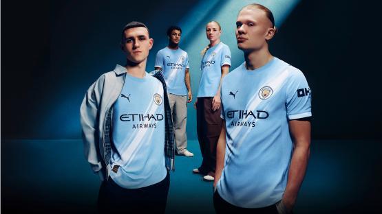 Models wearing Manchester City's new light blue Puma jerseys.
