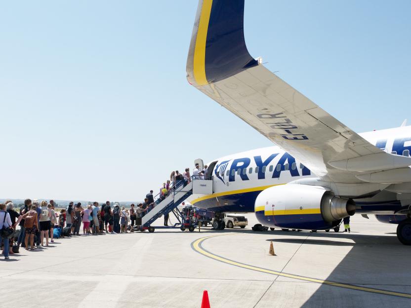Passengers queueing on an airfield to board a Ryanair airplane at Frankfurt-Hahn Airport.