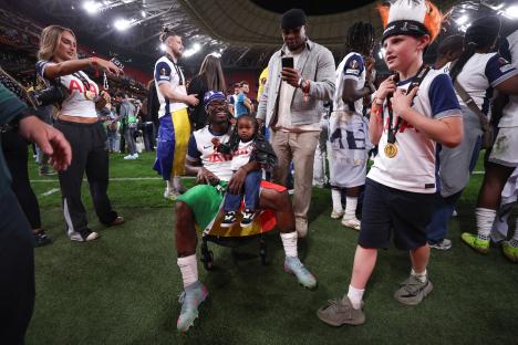 Yves Bissouma of Tottenham Hotspur celebrates with his daughter after a soccer game.