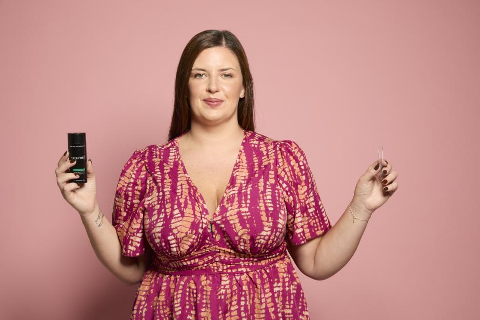 Charlotte Dodds holding hair treatment and tweezers, discussing pulling out her hair.