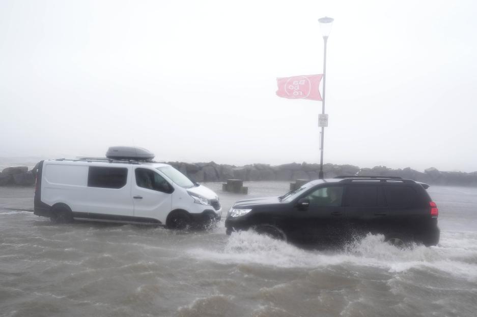 Two vehicles drive through floodwater in Galway during a storm.