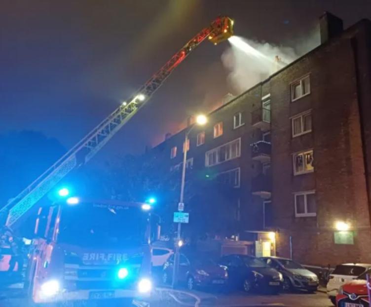 Fire Breaks Out in Battersea Flats..An explosion has been reported following a significant fire that erupted in a block of flats in Battersea, south west London. The incident began shortly before 7.10pm on September 10, 2025, engulfing the entire top floor of the four-storey building on Maysoule Road......The blaze has caused extensive damage, with flames breaking through the roof and exposing charred rafters. Emergency services have treated three individuals, one of whom was transported to the hospital...Witness Accounts..Local resident Alex shared his experience saying, 'I had just arrived home when I opened the window and the smell was suffocating. The smoke was so bad we couldnt see much outside the window. It was like smog.'........Blaze rips through Battersea Property after reported Explosion..Firefighters were seen evacuating residents, as captured in videos circulating on social media. A livestream on TikTok displayed thick smoke rising from the building, illuminated by the fire well into the night...Emergency Response..The London Fire Brigade received 33 calls regarding the blaze. Ambulance services arrived at the scene near the junction of Hope Street and Benham Close shortly before 7.30pm......Blaze rips through Battersea Property after reported Explosion..An ambulance spokesperson stated, 'We sent resources including ambulance crews, an incident response officer, and members of our Hazardous Area Response Team......Blaze rips through Battersea Property after reported Explosion..This incident is ongoing, and we are working alongside our emergency service partners at the scene.'..The cause of the fire remains under investigation.