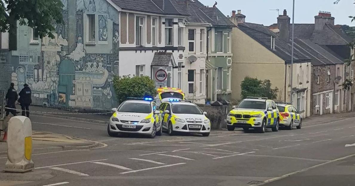 Police vehicles parked on a street in Callington during drug raids.
