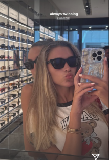 Woman taking a selfie with her friend in sunglasses.