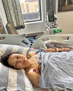 Woman recovering in hospital bed after heart surgery.