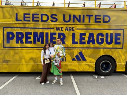 Ethan Ampadu with family in front of a Leeds United Premier League bus.