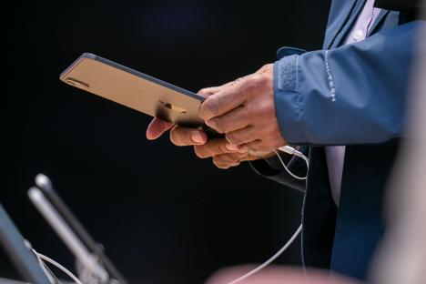 a man in a blue jacket is holding an apple phone