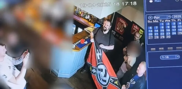 CCTV footage of a man displaying a neo-Nazi flag in a pub.