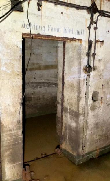 Flooded WWII Nazi bunker with German writing on the wall.