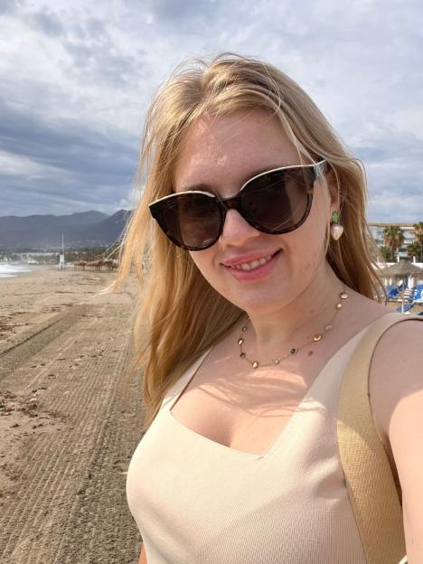Anastasiia Chikina smiling on a beach.