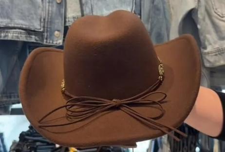 Brown cowboy hat with brown ribbon, shown with denim jackets and jeans.