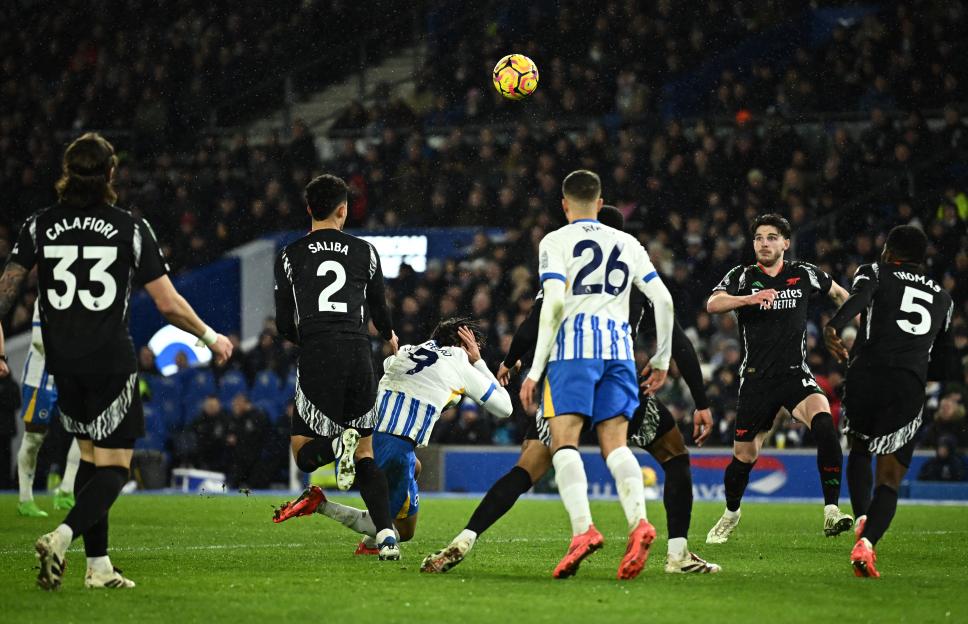 Arsenal's William Saliba fouls Brighton & Hove Albion's Joao Pedro in a soccer match.