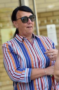 A woman wearing sunglasses and a striped shirt outside a coroner's court.