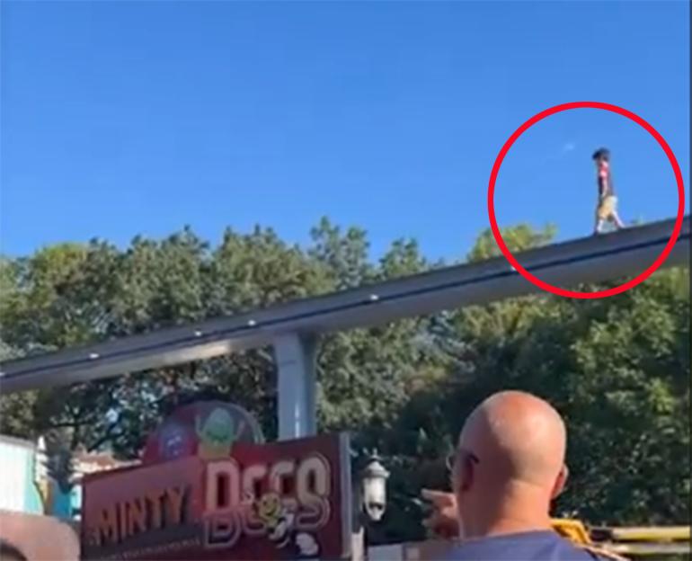 Boy walking on top of a monorail track.