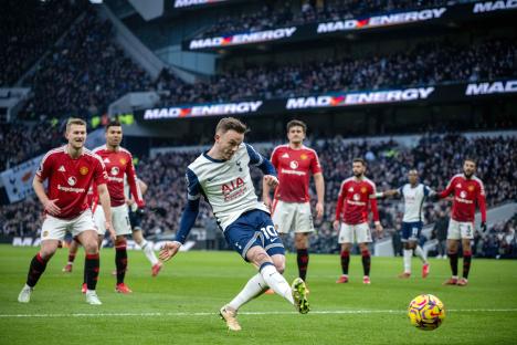 James Maddison of Tottenham Hotspur FC kicking a soccer ball during a match.