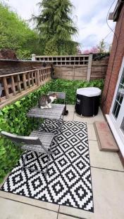 Small patio with table, chairs, cat, and inflatable hot tub.