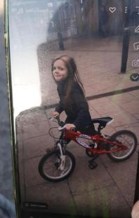 Girl on a red bike.