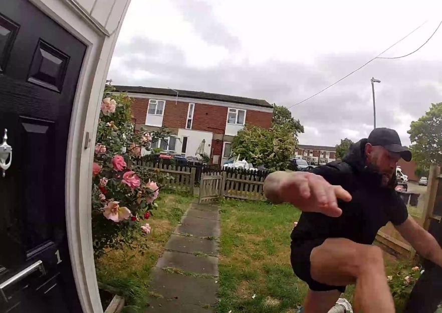 Doorbell footage showing a man in a black shirt and cap lunging towards the camera, damaging the property.