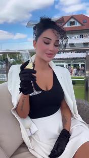 Tulisa at Chester Races, holding a glass of champagne.