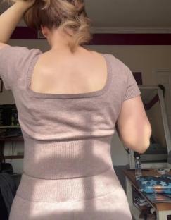 Woman's back in a pink outfit.