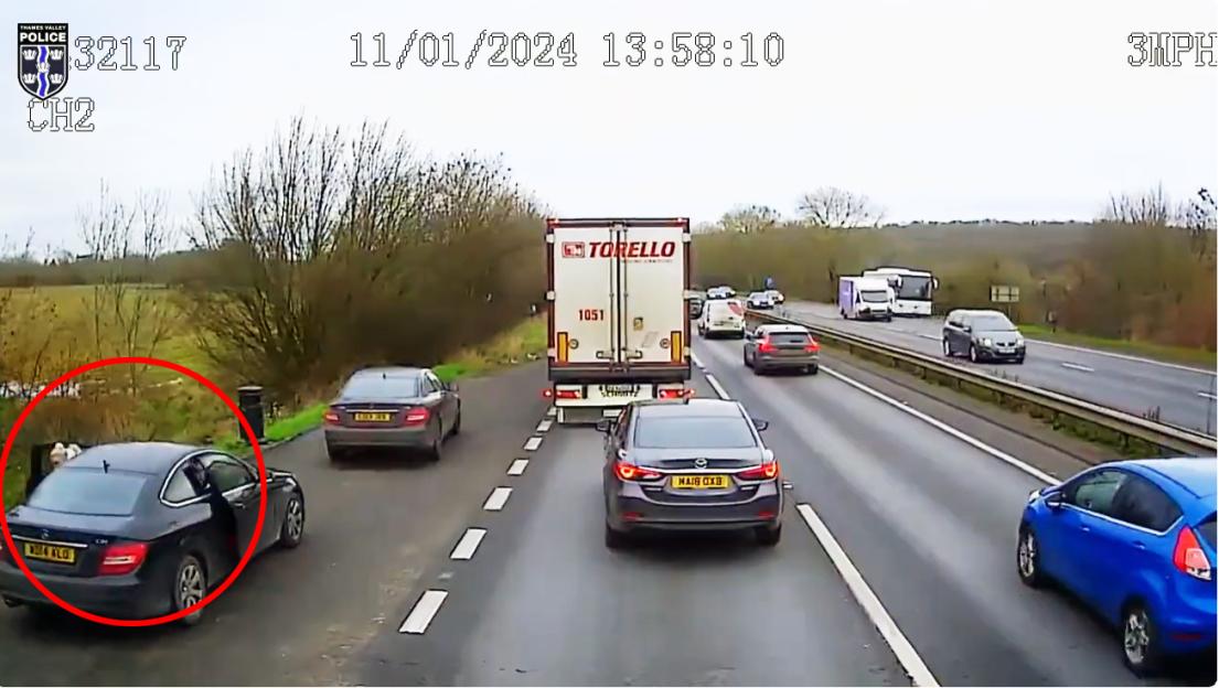 A woman exits a black car in a layby as an out-of-control lorry drives by.