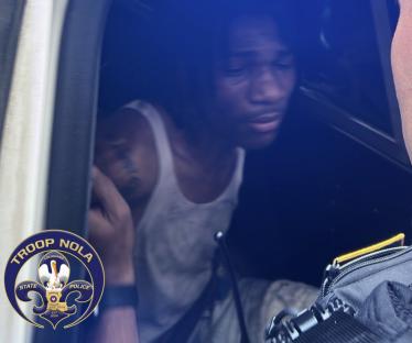 Arrested man in police vehicle.