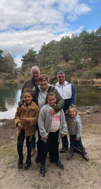 Alan Kirby with his partner and family by a lake.