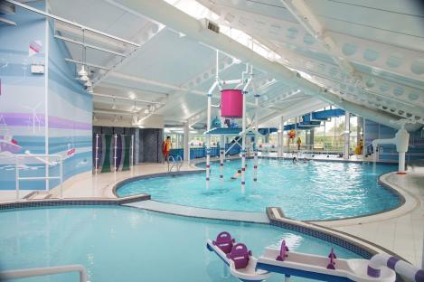 Indoor pool with water features and slides.