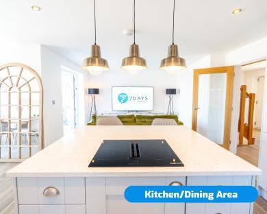Kitchen and dining area with island and induction cooktop.