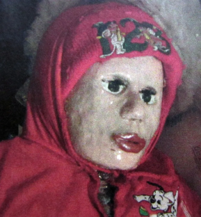 Child wearing a red hooded sweatshirt with cartoon characters on it.