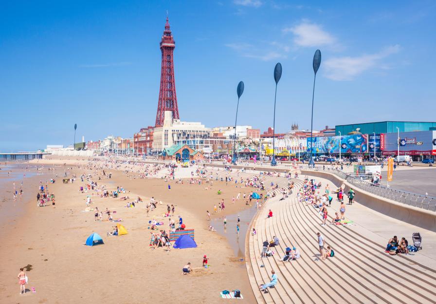 Blackpool beach and tower with many people enjoying a sunny day.