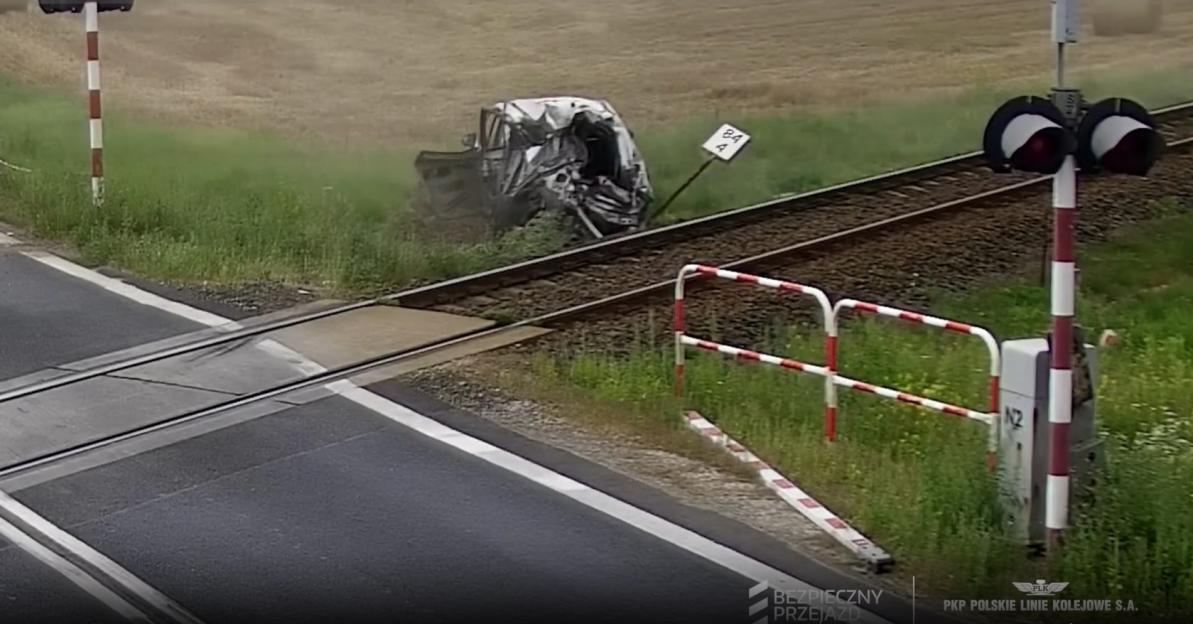 Car crashes through railway barrier and is hit by train.