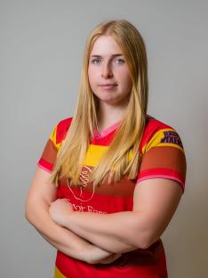 Portrait of Jennie Logan, a firefighter, wearing a rugby shirt.