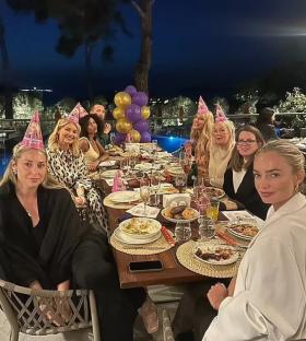Group of women celebrating at an outdoor dinner party.
