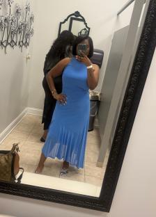 Woman in blue dress taking a selfie in a mirror.