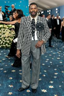 Colman Domingo at the Met Gala in a black and white grid patterned blazer and gray trousers.