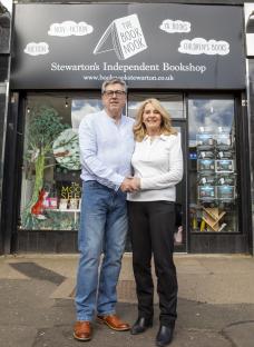 Couple standing outside their bookstore.