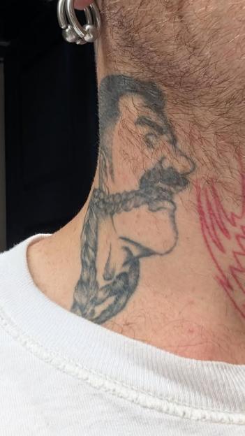 Neck tattoo of a bound face.