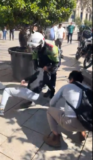Police officers arresting a person on the ground.