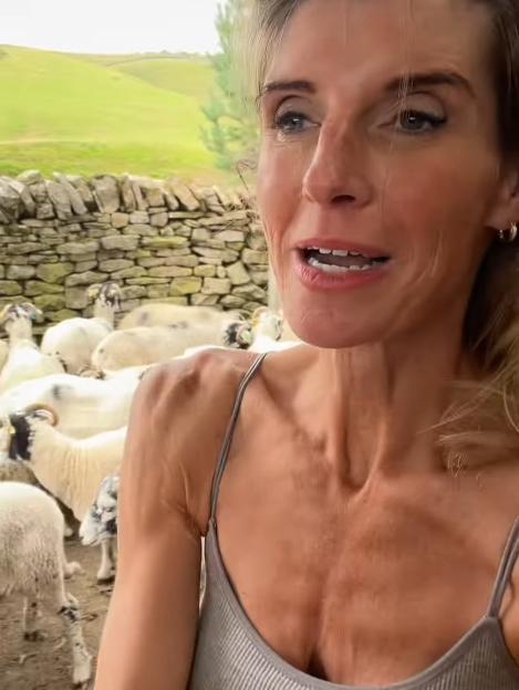 Amanda Owen speaking with sheep in a pen.