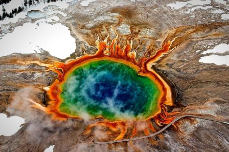 Aerial view of a geothermal area with a vibrant hot spring.