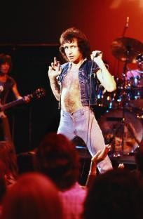 Bon Scott of AC/DC performing on stage.