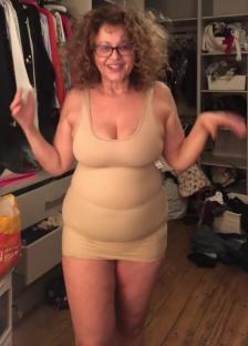 Woman in beige shapewear in front of a closet.