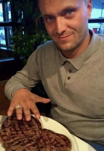 Man gesturing towards a large steak on a plate.