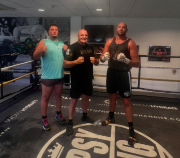 Three boxers in a boxing ring.