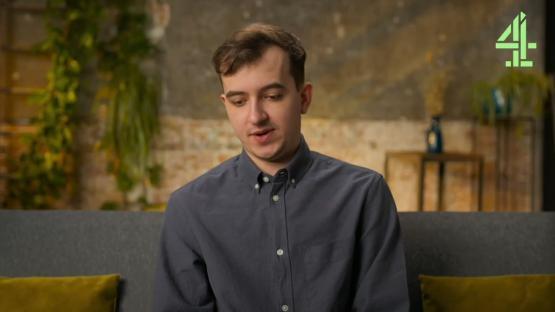 Man sitting on a couch, talking.